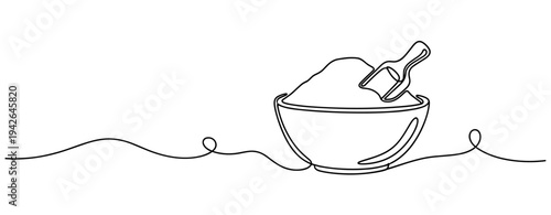 Mixing bowl with scoop of powder resting on simple countertop line
