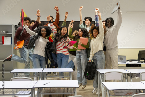 Diverse students celebrating success jumping in classroom