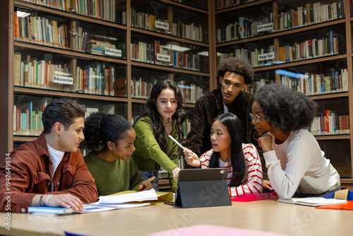 Diverse students collaborating on project in library