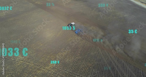 Plowing cab tractor pulling blue harrow across furrows, raising dust plume showing teal data road