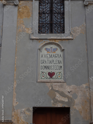 Fotografie Ave Maria gratia plena Dominus Tecum mosaic on an old building in Monticelli d'O