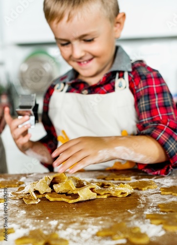 Принти на полотні Young boy making pasta, smiling and focused