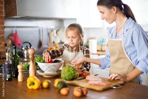 Fotografia Mother and daughter cooking together in a kitchen