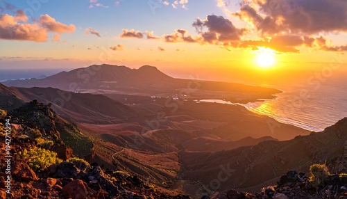 A scenic mountainous landscape at dawn, with the sun rising above the horizon, casting a warm golden glow over the sea