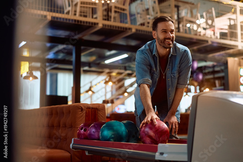 Foto Happy man enjoying while bowling at club.