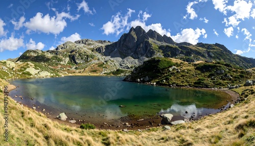 A scenic panorama of a mountain lake reflecting the clear sky and surrounding peaks, showcasing alpine wilderness
