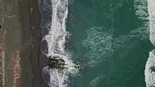 Aerial view of turbulent waves crashing against the dark sandy beach in a mesmerizing display of nature's raw power, Yilan, Yilan County, Taiwan.