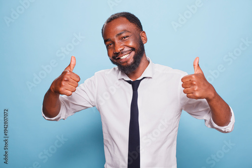 Bild auf Leinwand Portrait of african american man showing thumbs up sign in front of camera