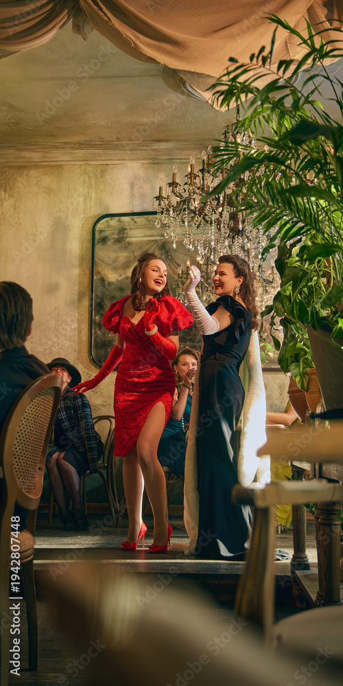 Fototapeta premium Two glamorous women performing dance in vintage cafe setting. Concept of cabaret style show promotion, themed restaurant marketing and luxury fashion storytelling visuals.