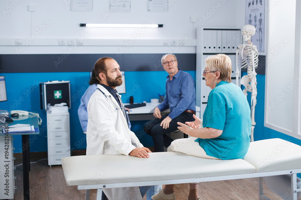 Obraz premium Elder woman consults with chiropractor for back pain. Senior patient receives medical help and therapy for physical recovery. The hospital offers physiotherapy exercises and rehabilitation.