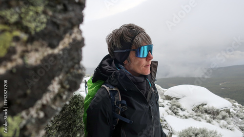 Mujer montañista en la nieve con gafas de sol