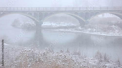 A winter snow scene of a stone bridge
