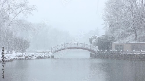 A winter snow scene of a stone bridge