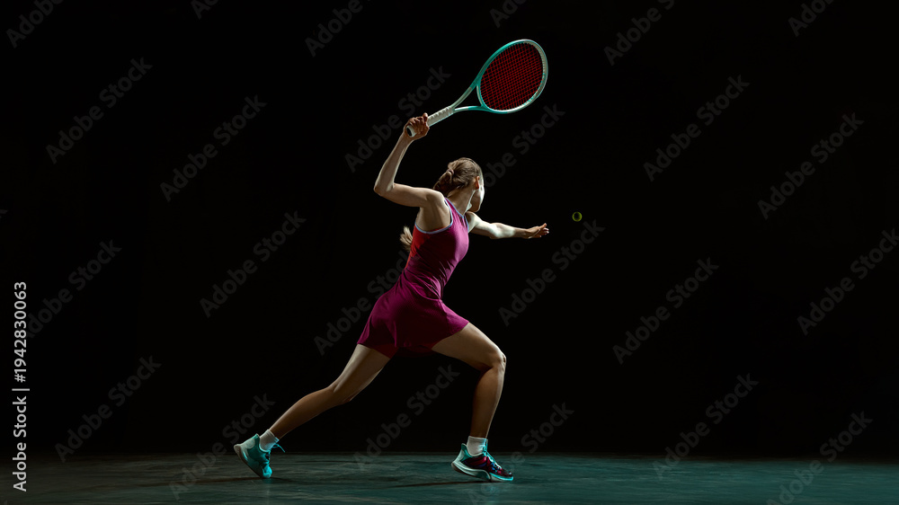 Fototapeta premium Female tennis player reaching for ball in dramatic motion. Concept of high intensity tennis training, sports advertising visuals for performance driven brand storytelling and promotion.