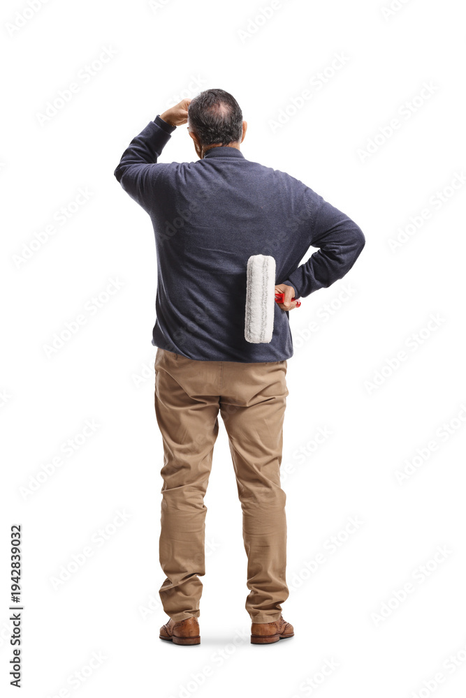 Fototapeta premium Rear view of a man holding a paint roller and thinking