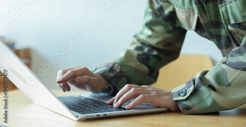 close up soldier man hand type o laptop to check security system of access data in private monitoring room with virtual icon for military operation control and command concept