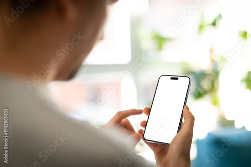 Smartphone Blank Screen Mockup in Hand – Close-Up with Soft Natural Light in Cozy interior