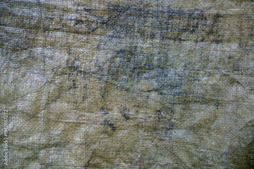 Weathered and dirty grey poly tarpaulin 