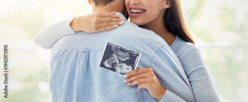 Fotografie A couple embraces while celebrating their pregnancy news