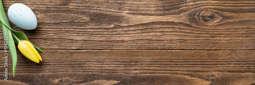 Horizontal Easter banner with pastel eggs and spring flowers on rustic wood