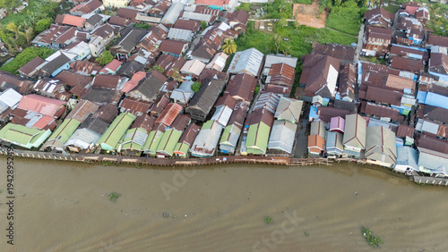 Aerial shot of a green village on the banks of the river in Banjarmasin, South Kalimantan in the afternoon