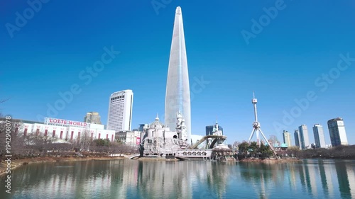Seoul, South Korea - Mar. 07, 2026 : 4K  video of Korean People Relaxing at Songpa Naru Park by Seokchon Lake in Winter, View of Lotte World
