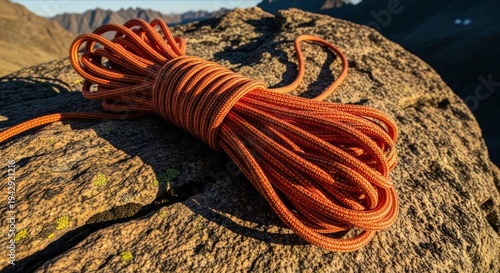 Coil of Bright Orange Rope on Rugged Rocky Surface in Nature