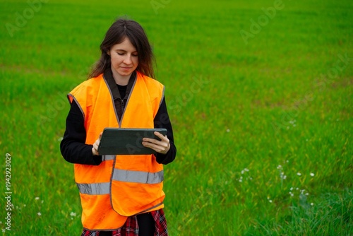 Agronomist using tablet in green agricultural field