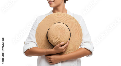 Woman in white shirt holding stylish straw hat close to her chest