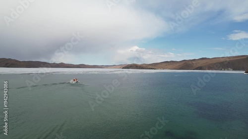 Lake Baikal in spring, ice drift in the lake. A hovercraft transports passengers to Olkhon Island 