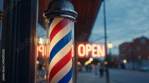 Classic barber pole glowing at dusk with an open sign in the background.