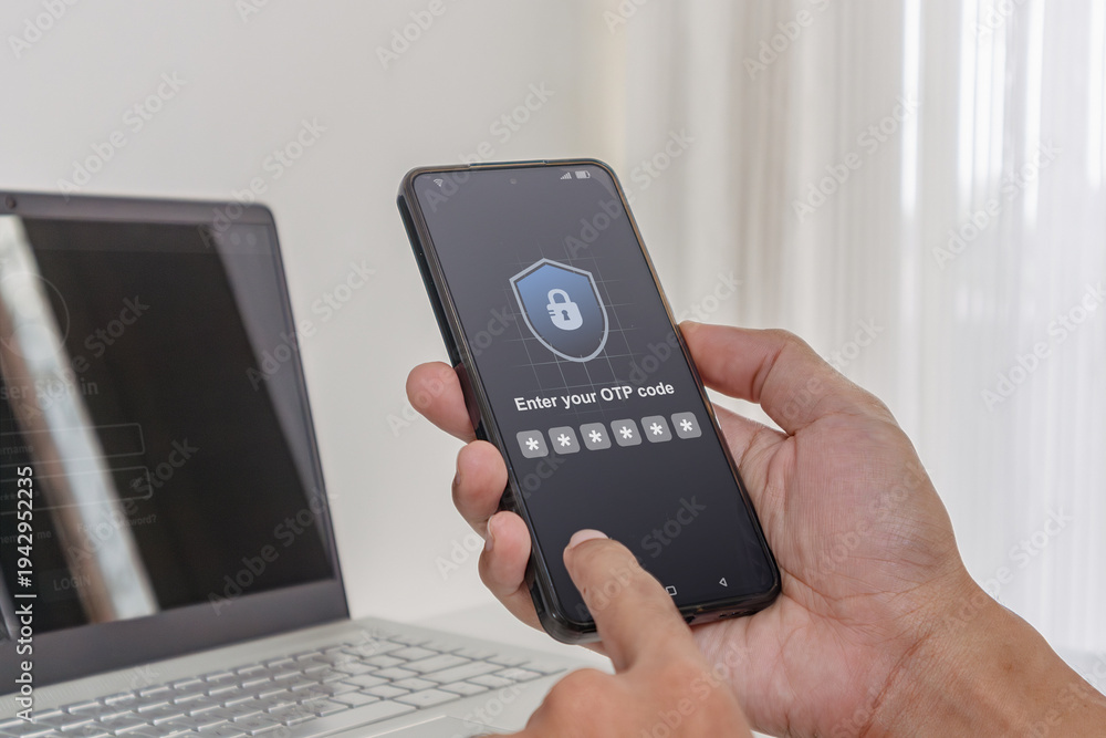Fototapeta premium Two factor authentication OTP code for secure login. A man using a laptop and smartphone to log in by entering One Time Password code.