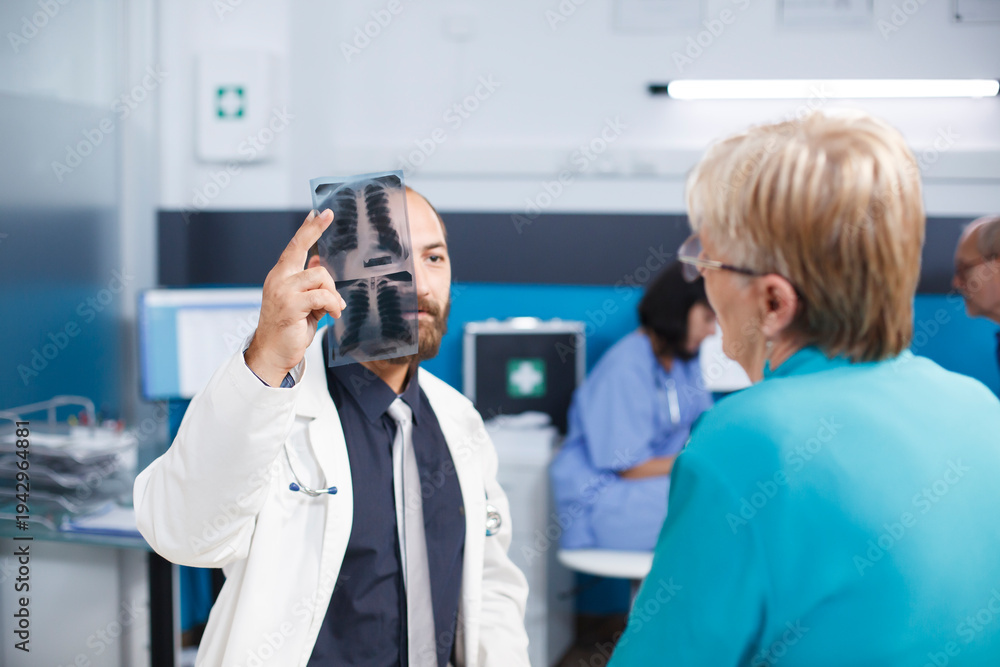 Obraz premium Mature patient consults specialist for back pain recovery. Physiotherapist provides medical support and suggests exercises. Treatment in hospital consulting room with digital X-ray.