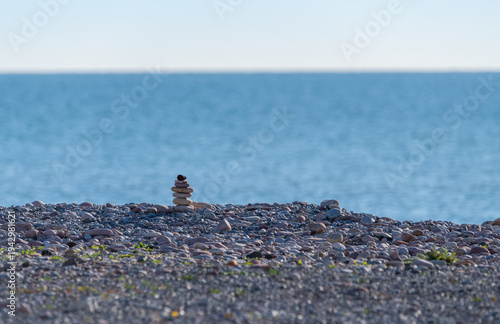 Wall Mural Rock Cairns on Sandy Beach with Ocean - Stacked Stones on Beach