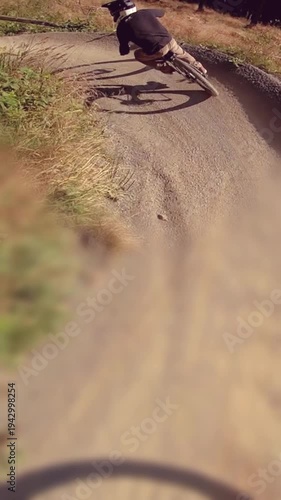 Kids having fun driving downhill MTB mountainbike on sunny day - vertical video
