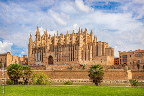 Wide view of the Gothic Cathedral of Santa Maria (La Seu) and Parc de la Mar reflection pool in Palma de Mallorca, Balearic Islands, Spain.