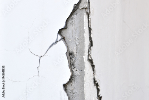 cracked concrete column corner with damaged plaster and structural failure