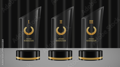 Three glass trophies with gold accents on a gray surface with