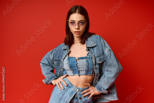 Schilderij op canvas Stylish young woman showcases denim fashion in a vibrant studio setting