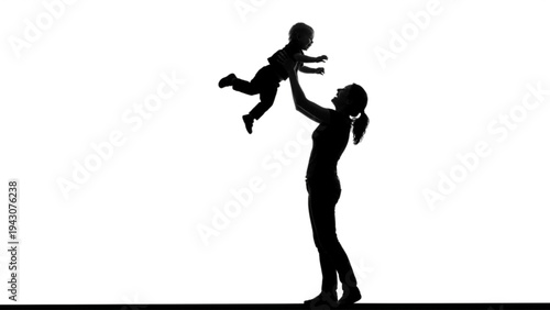 Silhouette of a happy mother lifting her toddler son high in the air against a white background