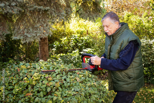 Foto Active senior man doing yardwork