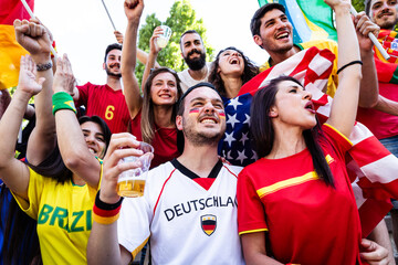 Sports fans supporting team with national flags cheering together