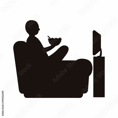 Silhouette of person relaxing on couch watching television while eating cereal
