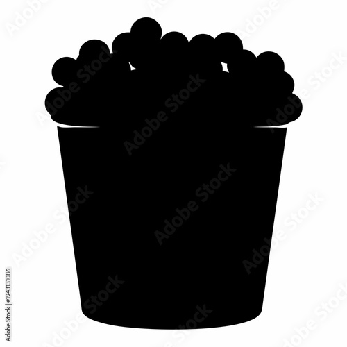 Full bucket of delicious popcorn in dark silhouette against white backdrop