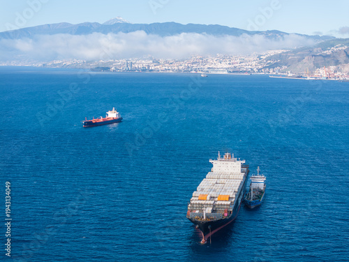 Cargo ships in the ocean with the Port of Santa Cruz de Tenerife in the background.