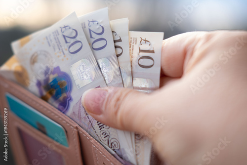 Foto wallet with British GBP banknotes, cash in female hands, counting uk pounds bill