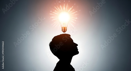 Silhouetted Man Looking Up at Glowing Light Bulb Above Head