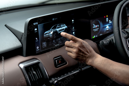 Cuadro en lienzo Close up of driver hand interacting with infotainment touchscreen displaying car interface and connectivity features inside modern vehicle dashboard