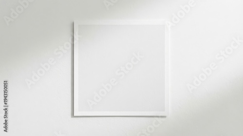 A clean minimalist square mirror on a white wall