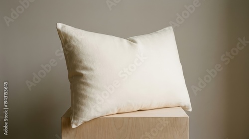 Cream linen pillow on light wood surface